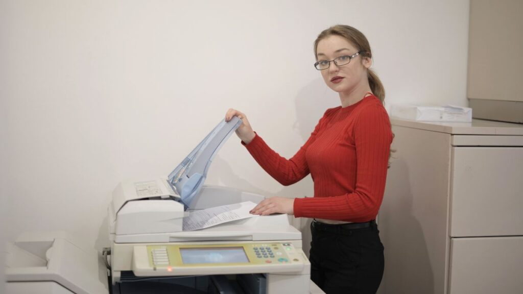 Uma mulher tirando xerox, ilustrando como o desenhista que saber como copiar um desenho se parece.